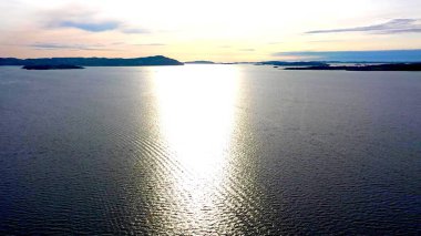 Adalar arasındaki denizde güneş yansıması, doğada harika bir an.