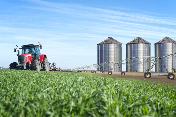 Concept of agriculture food chain production with watering system and silos.