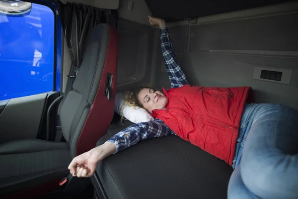 Estilo de vida do motorista de caminhão. Camionista acordando em sua cabine depois de um longo passeio. Caminhão interior cabine com motorista dormindo na cama . — Fotografia de Stock
