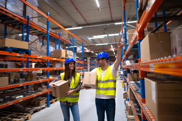 Workers carrying boxes and relocating items in large warehouse center. — Stok fotoğraf