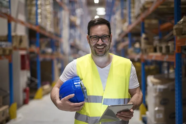 Portret van een glimlachende blanke magazijnmedewerker met tablet in de opslagruimte. — Stockfoto