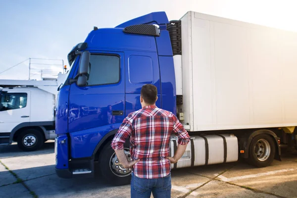 Professionele middelbare leeftijd vrachtwagenchauffeur in casual kleding op zoek naar vrachtwagen voertuig en gaan voor een lange transport rijden. — Stockfoto