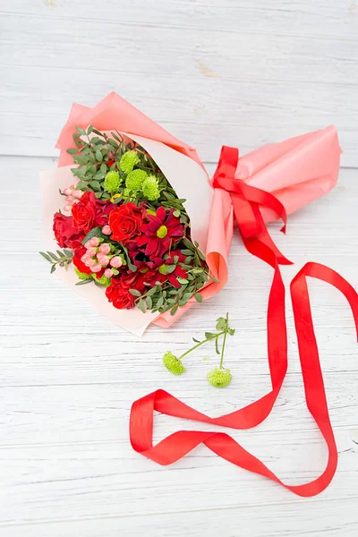 Ramo Rosas Con Crisantemos Verdes Embalaje Rojo Acostado Una Superficie —  Fotos de Stock