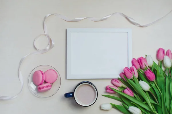 Coffee cup, spring tulip flowers and pink macarons on pastel table top view. Greeting for Womans or Mothers Day — Stock Photo, Image