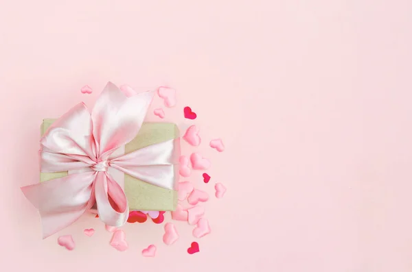 Present with pink bow on pink background with tittle hearts. Flat lay trendy style. — Stock Photo, Image