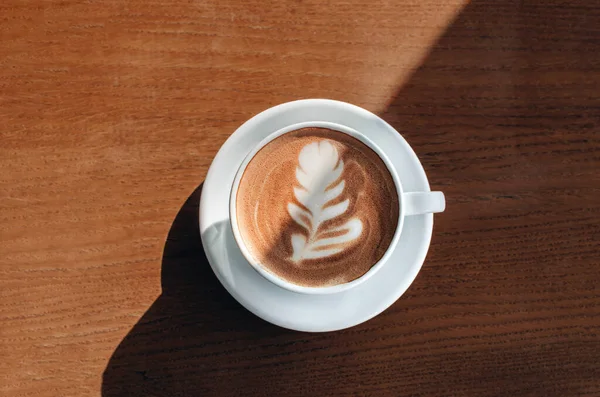 Morning coffee cup with nice art on it on wooden background — 图库照片