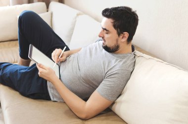 Erkek, evde fikirlerini çizmek için Stylus 'u tablette kullanıyor.