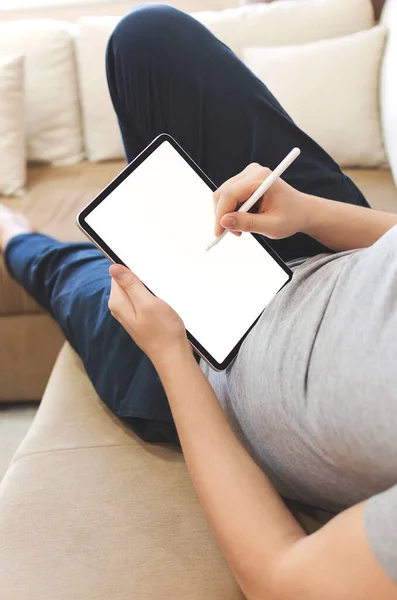 Male using stylus on tablet to draw his ideas at home