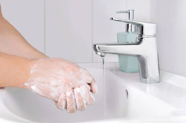 Male cleaning hands. Washing hands with soap to protect from coronavirus