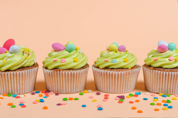 Row of bright pistachio Easter cupcakes with decorations close up