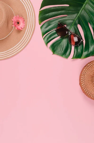 Sombrero de paja de verano, hoja de monstera tropical, gafas de sol, conchas, estrellas de mar sobre fondo rosa . — Foto de Stock