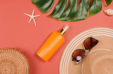 Yaz hasır şapkası, tropik canavar yaprağı, güneş gözlüğü, kabuk, güneş kremi, kırmızı arka planda deniz yıldızı. Üst görünüm, boşluk kopyala.