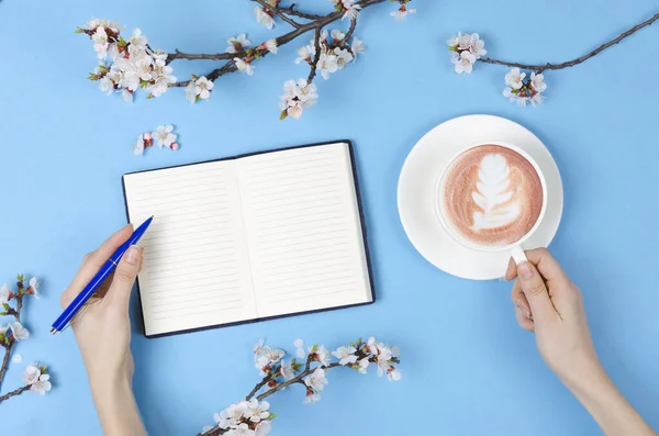 Wish list for future plans. flat lay composition with flowers, glasses and notepad and coffee with latte art