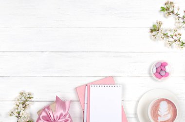 Çalışma masasının yaratıcı düzlüğü, istek listesi için not defteri ve ahşap arka plandaki yaşam tarzı nesneleri