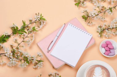 Çalışma masasının yaratıcı düzlüğü, istek listesi için not defteri ve sarı arkaplanda yaşam tarzı nesneleri