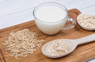 Tahta arka planda yulaf tohumlu yulaf ezmesi sütü