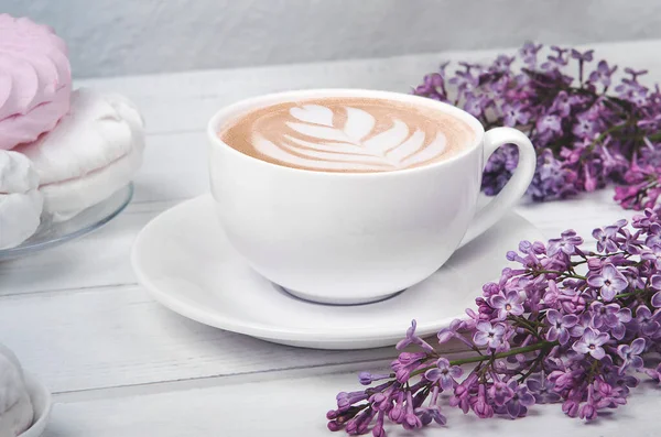 Lilás, xícara de café com arte latte e marshmallow na mesa de madeira branca. Depósito plano — Fotografia de Stock