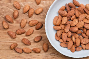 Tahta masadaki hafif kasede badem tohumlarının düz görünümü