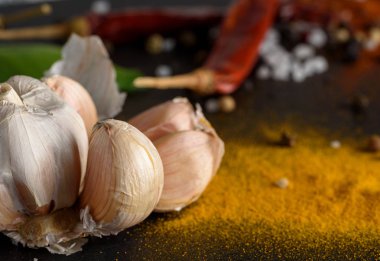 Taze sarımsak ve baharat siyah taş zemin üzerine