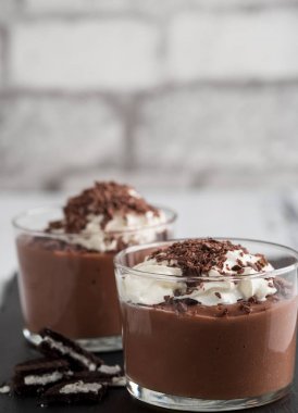 Bir gözlük siyah bir taş zemin üzerine çikolata mousse.