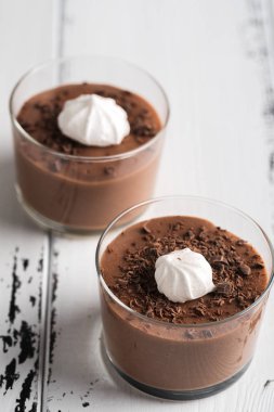 Beyaz ahşap zemin üzerinde bir bardaklarda çikolata mousse.