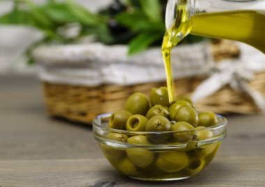 Taze zeytin ve zeytinyağı ahşap arka plan üzerinde. Zeytin zeytin dalında.