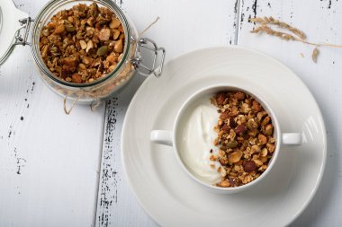 Sağlıklı Kahvaltı: granola ile beyaz kase ve kavanoz içinde ev yapımı granola ile Yunan yoğurt