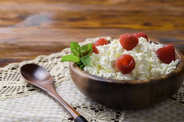 Taze ahududu kopya alanı metniniz için eski ahşap zemin üzerine ahşap bir kase süzme peynir. Üstten Görünüm