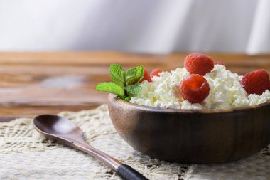 Taze ahududu kopya alanı metniniz için eski ahşap zemin üzerine ahşap bir kase süzme peynir. Üstten Görünüm