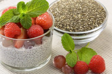 Bir bardak taze çilek ile sağlıklı Hindistan cevizi sütü chia puding yaprakları nane ve chia tohum cam kase