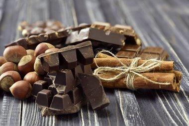 Koyu ahşap arka plan üzerinde Fındıklı çikolata parçaları. Seçici odak. Rustik tarzı.