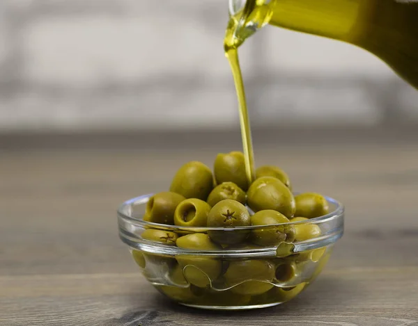 Aceitunas frescas y aceite de oliva sobre fondo de madera . — Foto de Stock