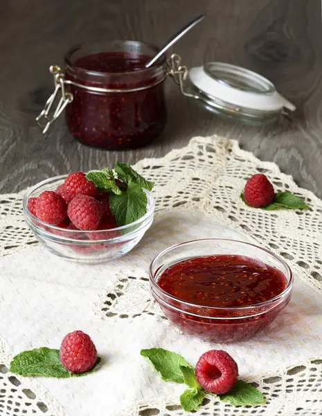 Mermelada de frambuesa en un frasco de vidrio con bayas de frambuesa frescas — Foto de Stock