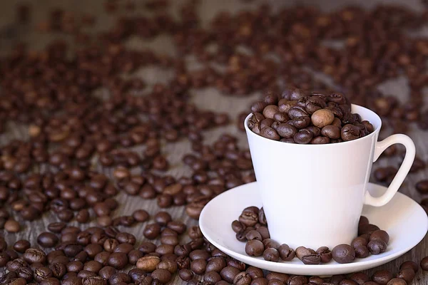 Conceito de café: grãos de café fritos em copo de café branco de porcelana — Fotografia de Stock