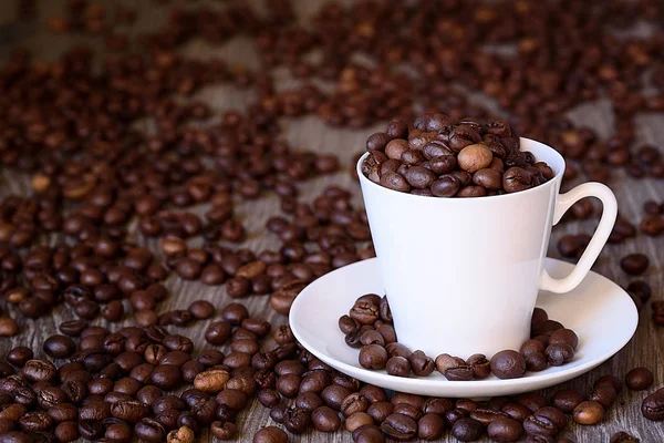 Conceito de café: grãos de café fritos em copo de café branco de porcelana — Fotografia de Stock