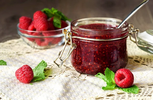 Mermelada de frambuesa en un frasco de vidrio con bayas de frambuesa frescas —  Fotos de Stock