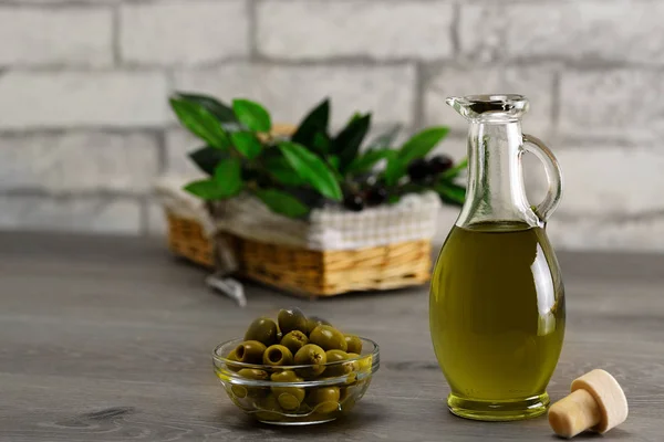 Aceite de oliva y rama de olivo sobre la mesa de madera — Foto de Stock