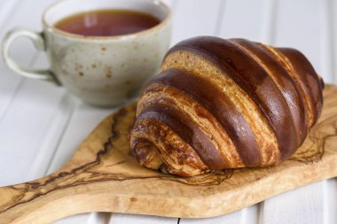 Geleneksel ahşap tabakta taze çikolatalı kruvasan