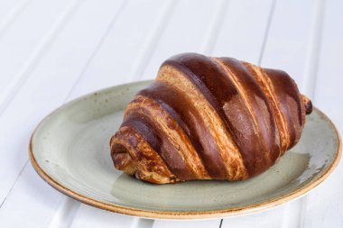 Çikolata taze kruvasanlar ve beyaz wo günü kahvaltıda çay bardağı