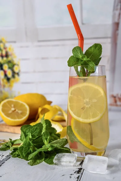 Refrescante bebida fría de verano con limón y menta en respaldo de madera —  Fotos de Stock