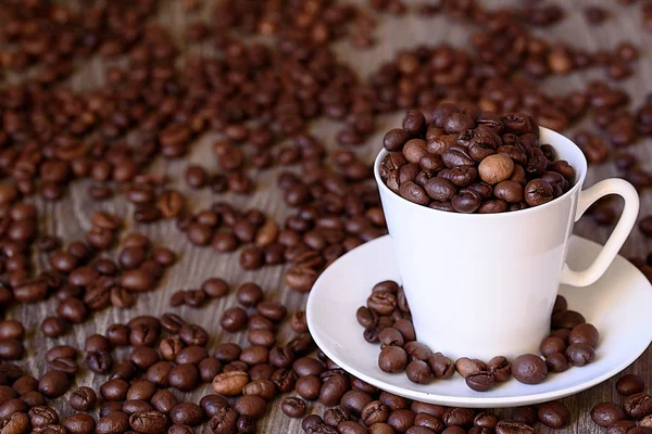 Conceito de café: grãos de café fritos em copo de café branco de porcelana — Fotografia de Stock