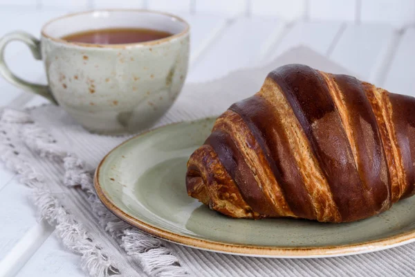 Croissants de chocolate fresco e xícara de chá para o café da manhã em wo branco — Fotografia de Stock