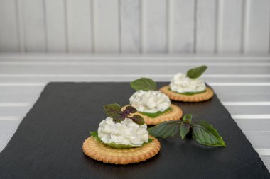 Bisküvi kraker meze ile krem peynir ve fesleğen tepesi