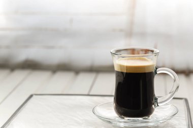 Espresso. Cam espresso fincan kahvenin üzerinde bir ışık backgr ile
