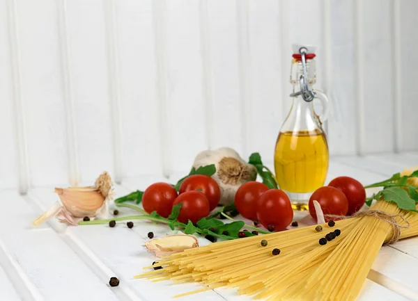 Ingredientes alimentarios para espaguetis italianos sobre fondo de madera blanco — Foto de Stock