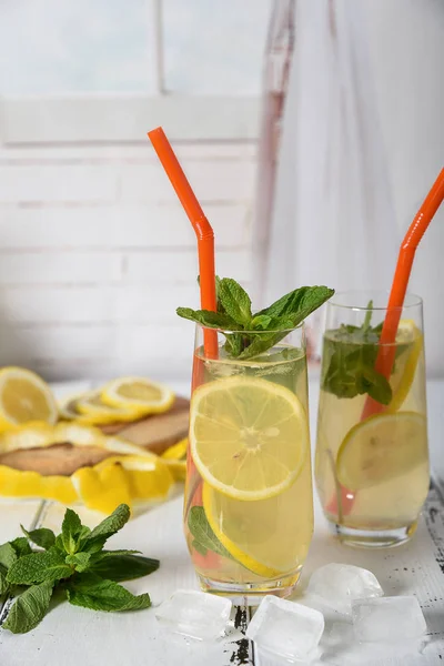 Холодный освежающий летний напиток с лимоном и мятой на деревянной спине — стоковое фото