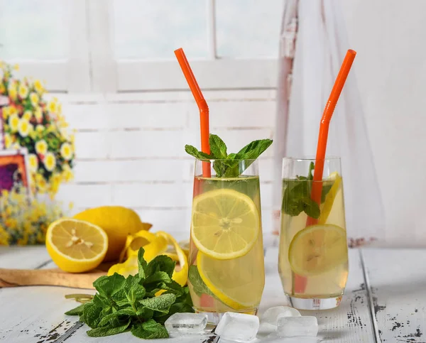 Холодный освежающий летний напиток с лимоном и мятой на деревянной спине — стоковое фото
