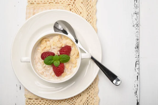 Steel cut oatmeal porridge with raspberry and almond flakes for