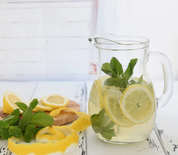 Подготовка лимонада в кувшине и лимонах — стоковое фото