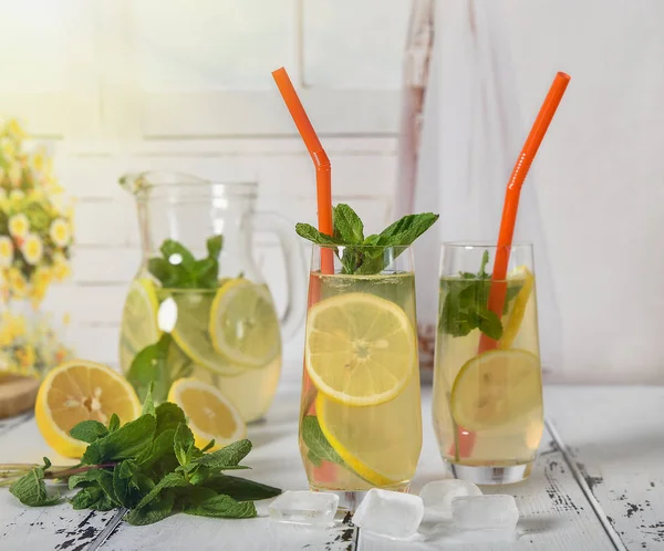 Refrescante bebida fría de verano con limón y menta en respaldo de madera —  Fotos de Stock